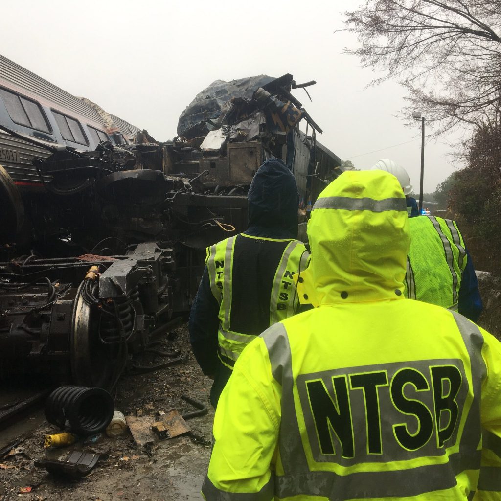 In this photo from the NTSB, members of the investigative team examine the scene of the collision that killed conductor Michael Cella.