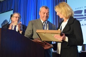 Washington State Legislative Director Herb Krohn, left, looks on as Transportation Division President John Previsich congratulates Washington state Sen. Patty Kuderer on receiving a Golden Spike award at the Seattle Regional Meeting.