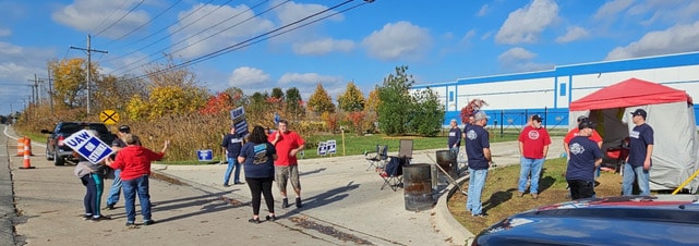 SMART-TD Local 1438 and Local 278 members walk with UAW Local 1248 members in front of Mopar Parts Distribution Center in Romulus, Mich.