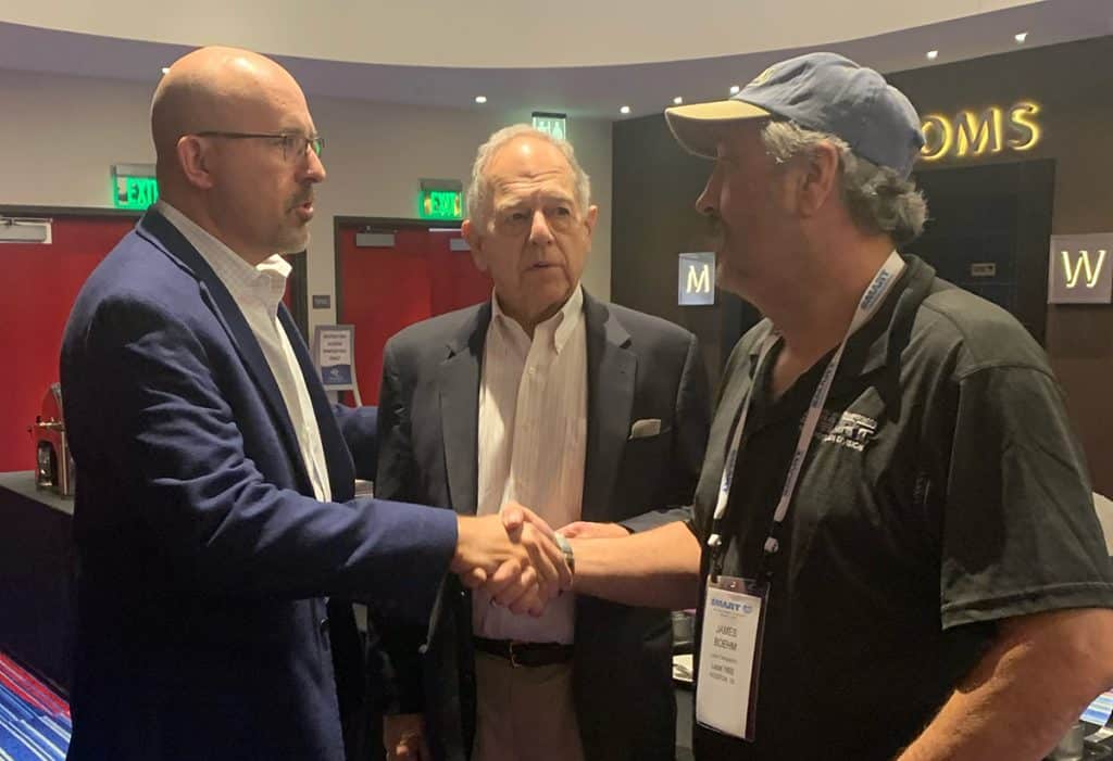 Transportation Division President Jeremy Ferguson shakes hands with Local Chairperson James Boehm as Surface Transportation Board Chairman Martin Oberman, center, looks on at the Davenport, Iowa, Regional Training Seminar in November 2023.